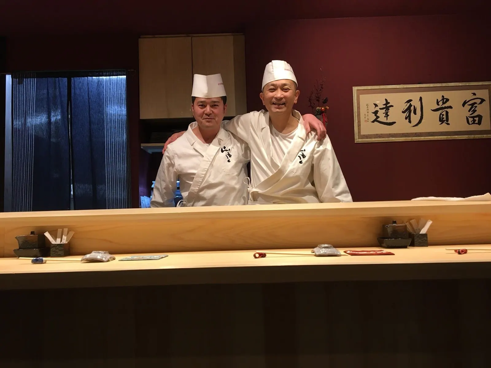 檜のカウンターに立つ大将と職人